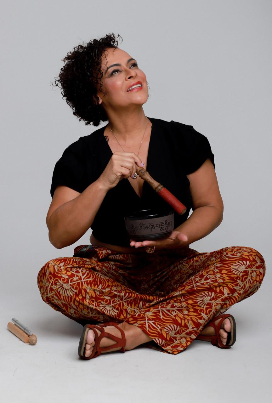 Adriana Resende, terapeuta holística, sentada com tigela tibetana
